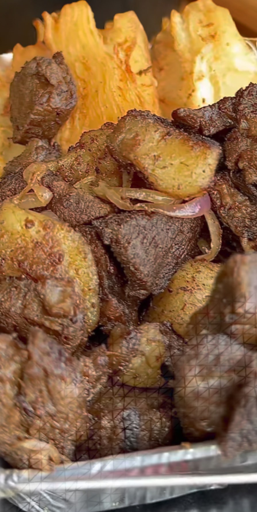 Viande de porc braisée servie avec plantains et pommes de terre sautées