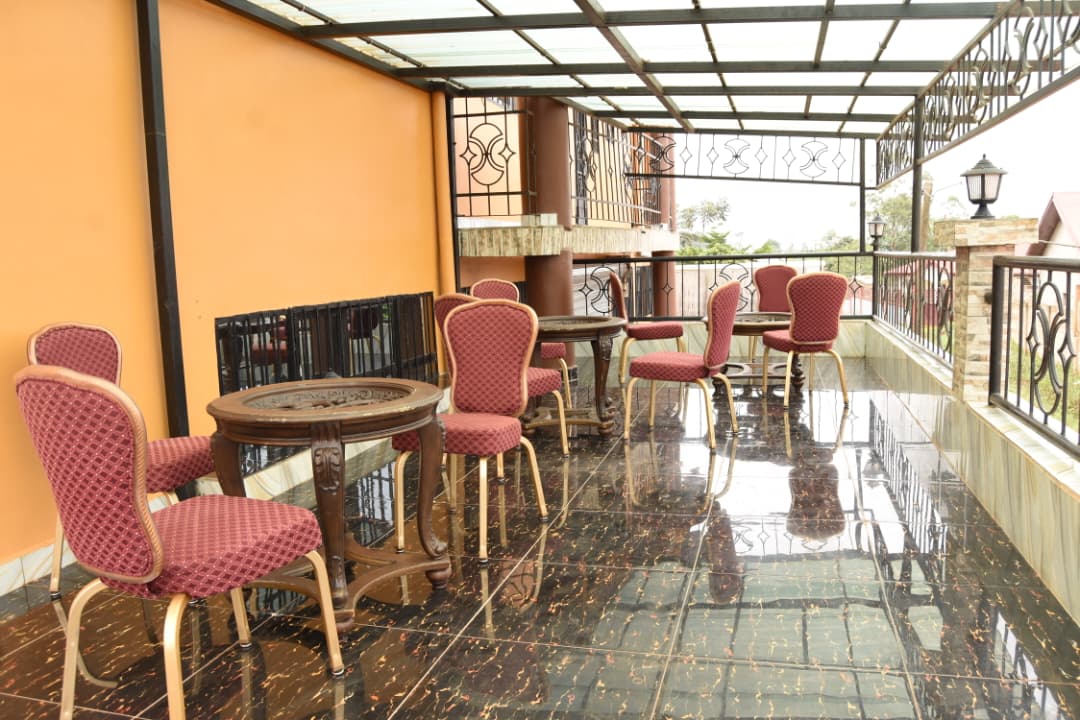 Terrasse salon couverte avec tables et fauteuils de l'Hôtel La Fraîcheur